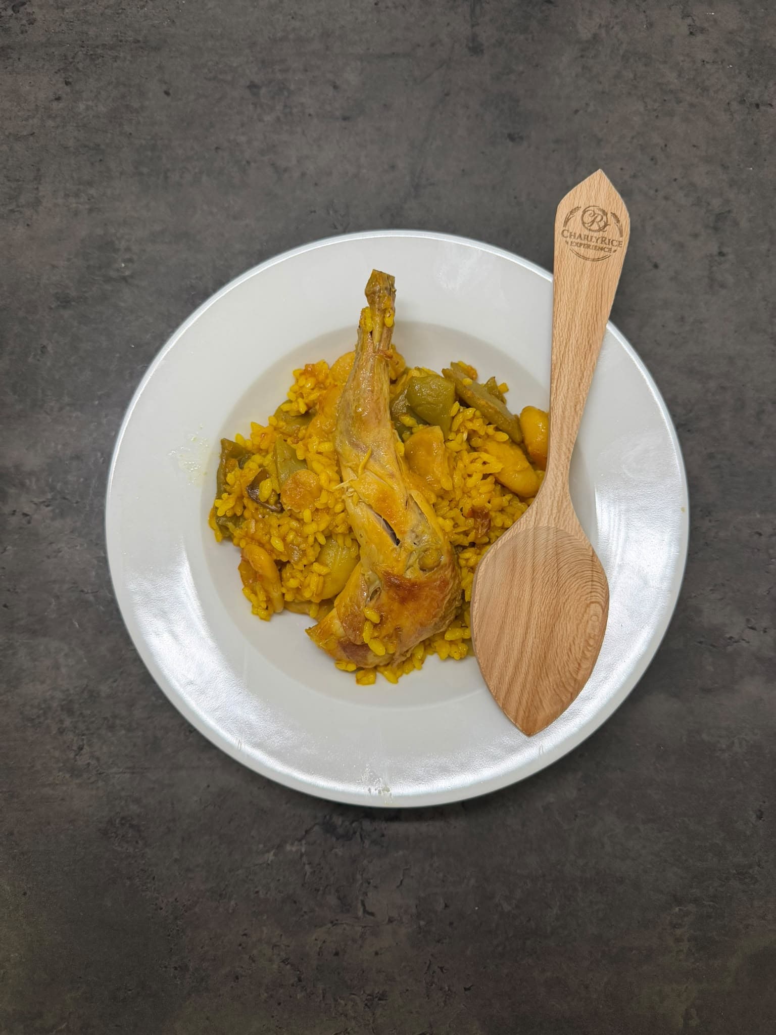 Ración de paella valenciana emplatada con la cuchara de la casa